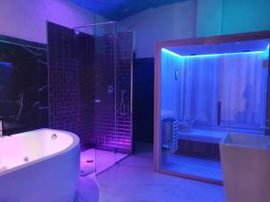 uma casa de banho com uma banheira e um chuveiro com luzes roxas em Setteabbracci Suite & Apartments em Baronissi