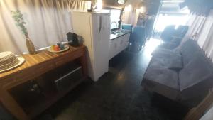 a kitchen and a living room with a couch and a table at LolosaBUS - Não é apenas uma hospedagem e sim uma EXPERIÊNCIA! in Ubatuba