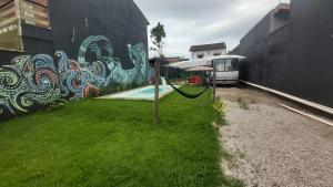a fence with a painting on the side of a wall at LolosaBUS - Não é apenas uma hospedagem e sim uma EXPERIÊNCIA! in Ubatuba +3 photos