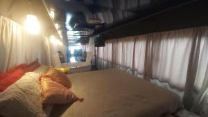 a bedroom with a large bed with white curtains at LolosaBUS - Não é apenas uma hospedagem e sim uma EXPERIÊNCIA! in Ubatuba