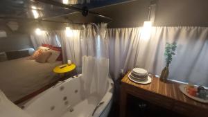 a bathroom with a large tub and a bed and a tub at LolosaBUS - Não é apenas uma hospedagem e sim uma EXPERIÊNCIA! in Ubatuba