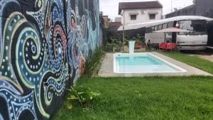 a wall with a painting on it next to a pool at LolosaBUS - Não é apenas uma hospedagem e sim uma EXPERIÊNCIA! in Ubatuba