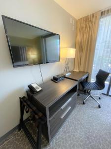a hotel room with a desk with a television on the wall at Aqua Palms 306 condo in Honolulu