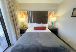 a bedroom with a bed with a red pillow on it at Aqua Palms 306 condo in Honolulu