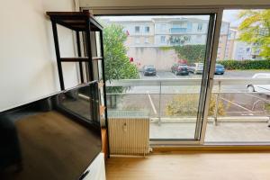 a kitchen with a large window with a view of a street at Furnished Apartment With Balcony & Parking in A Secure Residence in Pessac