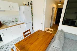 salon z drewnianym stołem i kanapą w obiekcie Furnished Apartment With Balcony & Parking in A Secure Residence w mieście Pessac