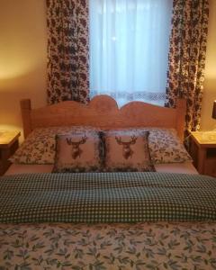 a bedroom with a bed with a window with curtains at Chata Litwor in Bukowina Tatrzańska