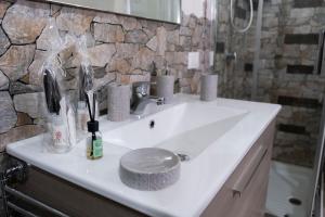 a white sink in a bathroom with a stone wall at A due passi dal centro e dal mare in Marsala +39 photos