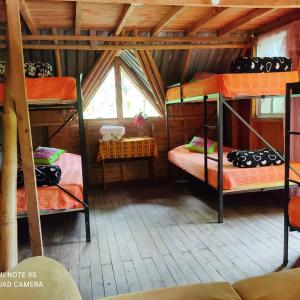 a room with three bunk beds in a cabin at Hospedaje Pance Arí Munani Reserva Natural in Cali