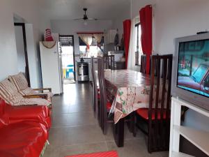 een woonkamer met een eettafel en een televisie bij Casa de Praia em Barra Velha Itajuba SC por Temporada in Barra Velha