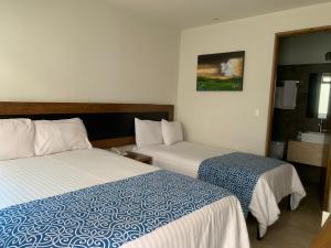 Habitación de hotel con 2 camas y baño en Rymma Hotel en Morelia