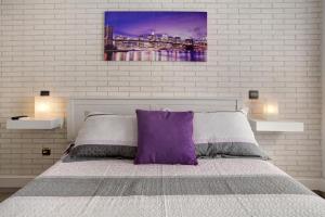 una camera con letto e cuscino viola di Magara Suite Las Canteras a Las Palmas de Gran Canaria