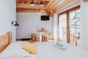 a bedroom with a white bed and a large window at Penzión Natália in Terchová +91 photos