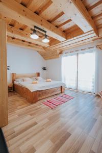 a bedroom with a bed and a wooden ceiling at Penzión Natália in Terchová