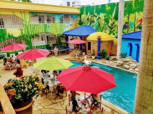 坦皮科的住宿－HOTEL ESMERALDA，一群人坐在泳池附近的伞下
