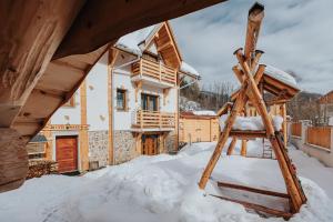 a wooden ladder in the snow in front of a house at Penzión Natália in Terchová