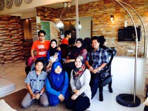 a group of people posing for a picture in a living room at AGODA C VIEW @ Sri Sayang Beach Resort in Batu Ferringhi
