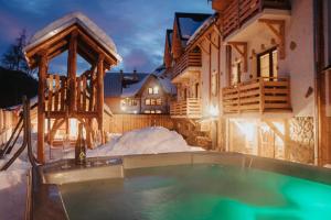 a house with a swimming pool in the snow at Penzión Natália in Terchová