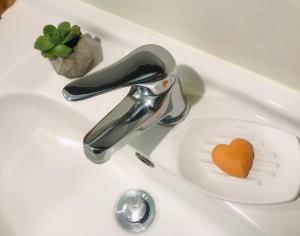 a sink with a faucet with a heart on a drain at Frangipani guesthouse -Ngunguru in Whangarei