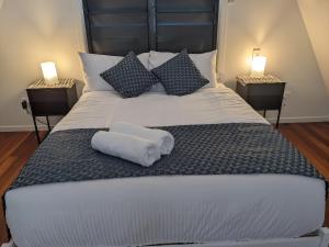 a large white bed with two nightstands and two lamps at Canopy 5 Chalet in Nelly Bay