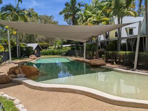 a swimming pool with a canopy over it at Canopy 5 Chalet in Nelly Bay
