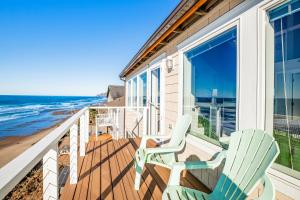 two chairs on a balcony with the beach at Cape Kuh'lye in Lincoln City