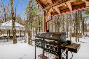 una parrilla al aire libre en la nieve con una tienda de campaña en The Scrabble House, en New Rome