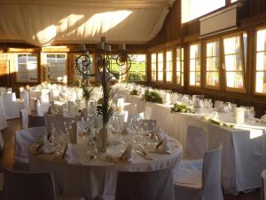 Cette grande chambre comprend des tables et des chaises blanches ainsi que du linge de maison blanc. dans l'établissement Rosis Sonnbergstuben, à Kitzbühel