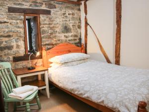 a bedroom with a bed and a table and a chair at Swallow Cottage in Bucknell