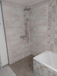 y baño con ducha y bañera blanca. en Le Soulier En Cévennes 4 étoiles en Saint-Martin-de-Valgalgues