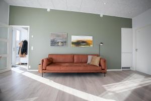 un sofá en una sala de estar con una pared verde en New 2 Bedroom Apartment With Sea View en Tórshavn