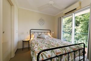 um quarto com uma cama e uma janela em Charming CBD Apt 3bd 2bth - walk to Waterfront em Darwin