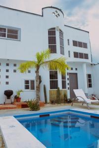 a villa with a swimming pool in front of a house at Rooms in Cancun Airport in Cancún