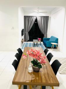 a wooden table with flowers on it in a living room at Imperio Condostay Alor Star in Alor Setar