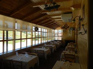 a row of tables in a room with windows at Hotel Vallefura in Pescocostanzo
