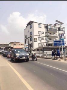 Une voiture descendant dans une rue à côté d'un bâtiment dans l'établissement HOTEL MALLIKA COMPANY, SL, à Freetown