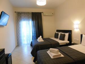 a hotel room with two beds and a television at Anna house 4 in Sarti