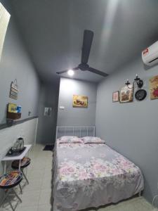 a bedroom with a bed and a ceiling fan at Sya Cottage in Kuala Pilah