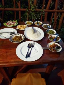 a wooden table topped with plates and bowls of food at The Horizon Root Inn in Ella