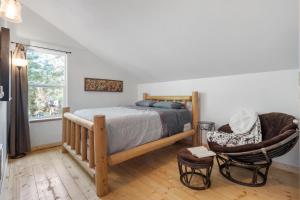 a bedroom with a bed and a chair and a window at Kelton's Cabin in Ashford