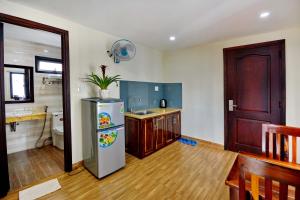 a kitchen with a refrigerator and a sink at Harvey Hotel & Apartments in Nha Trang