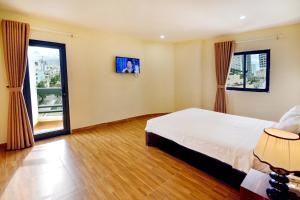 a bedroom with a bed and a large window at Harvey Hotel & Apartments in Nha Trang