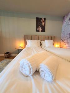 a large white bed with white sheets and pillows at Eriss Studio Suite - OZone building apartment in Cluj-Napoca