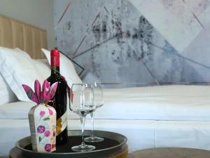 a bottle of wine and two glasses on a table at Eriss Studio Suite - OZone building apartment in Cluj-Napoca +25 photos