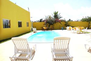 um pátio com cadeiras e uma piscina em Viana Praia Hotel em Piaçabuçu