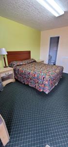 a bedroom with a bed with a colorful bedspread at Longhorn Motel Boise City in Boise City