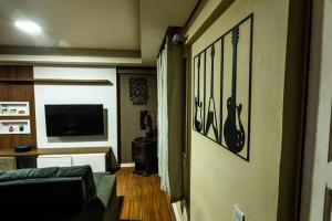 een woonkamer met een bank en een flatscreen-tv bij Apartamento Completo de 3 quartos em Gramado 2 in Gramado