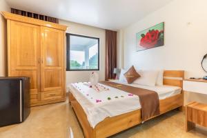 um quarto de hotel com uma cama e uma televisão em Cat Ba Rose Nhung Hotel em Ilha de Cát Bà