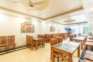 a dining room with wooden tables and chairs at Cat Ba Rose Nhung Hotel in Cat Ba