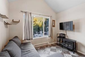 uma sala de estar com um sofá e uma janela em Cozy Tiny Home Steps Away From Mt. Rainier em Ashford